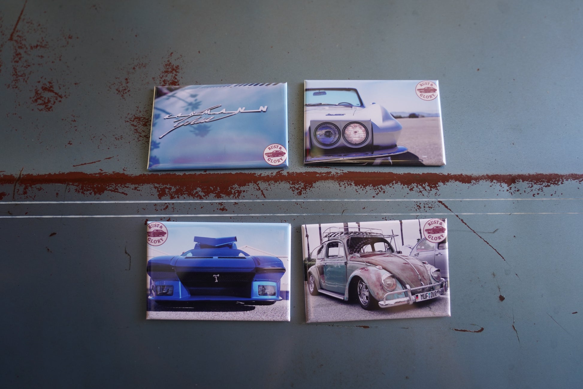 Four magnets featuring vintage cars on a textured blue surface.