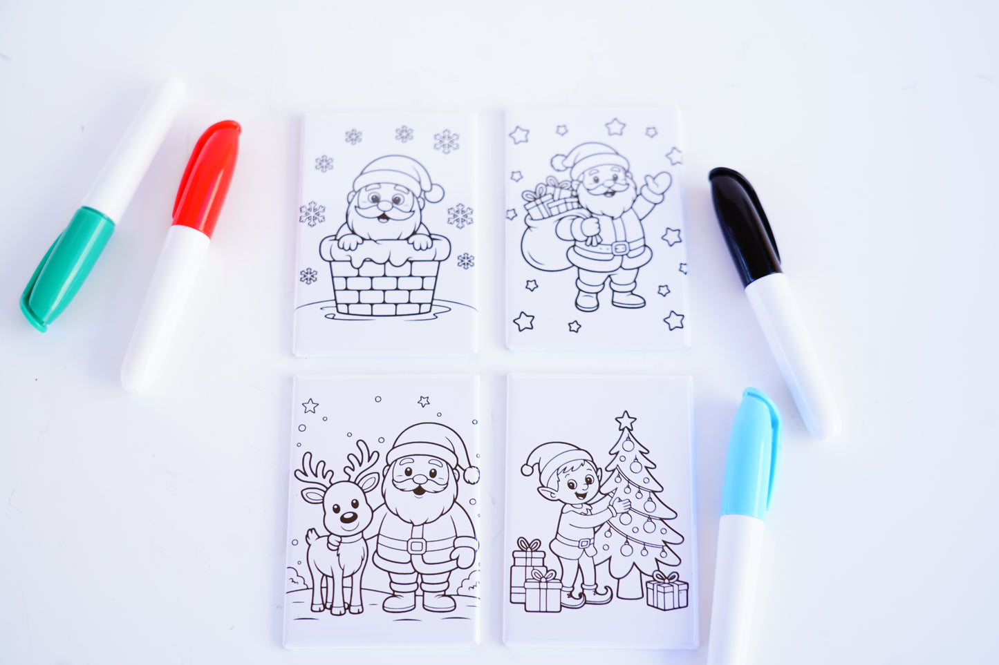 Coloring book with Christmas-themed pages and markers on a white background