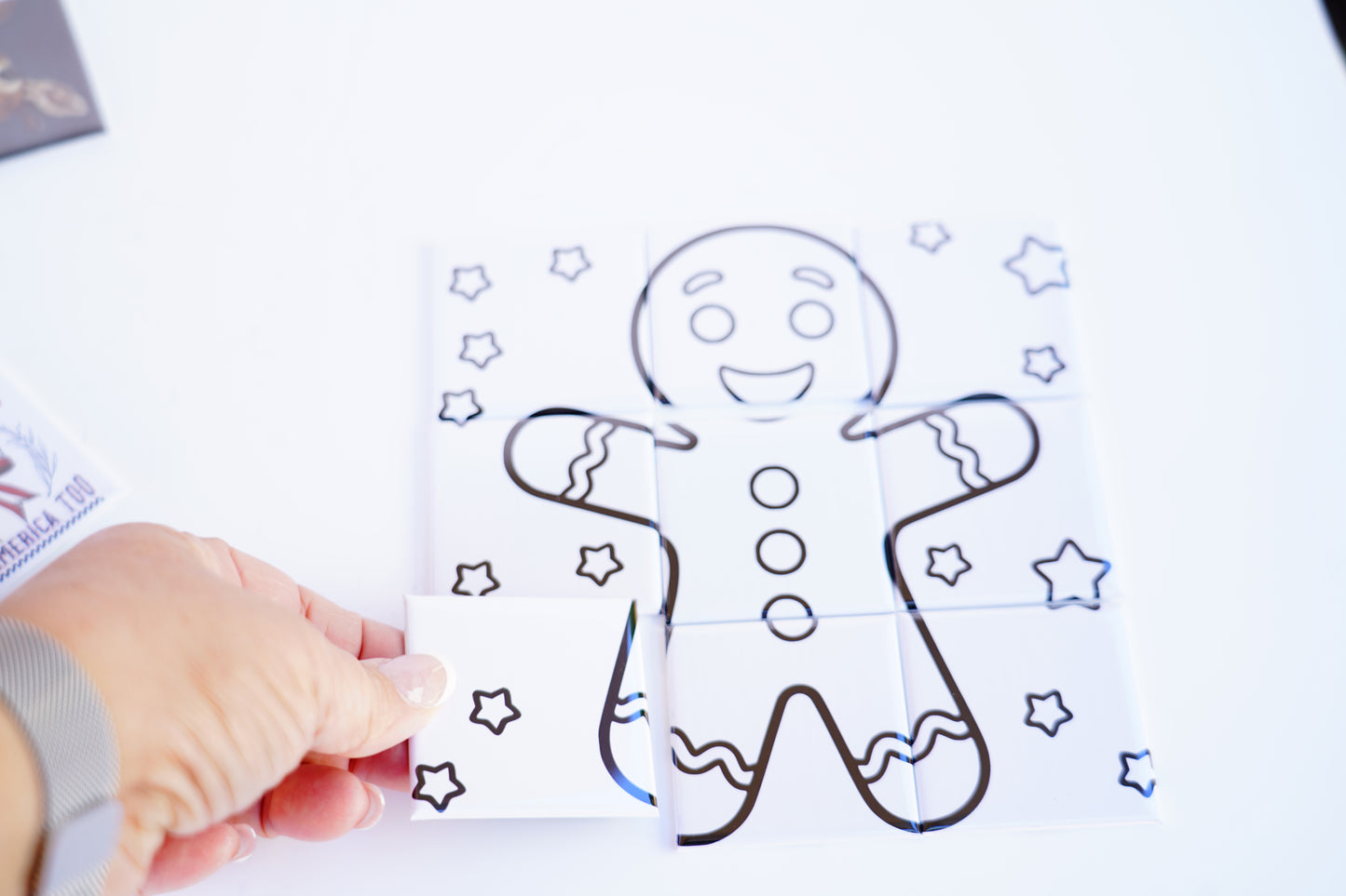 Hand placing puzzle piece – dry erase gingerbread magnet
